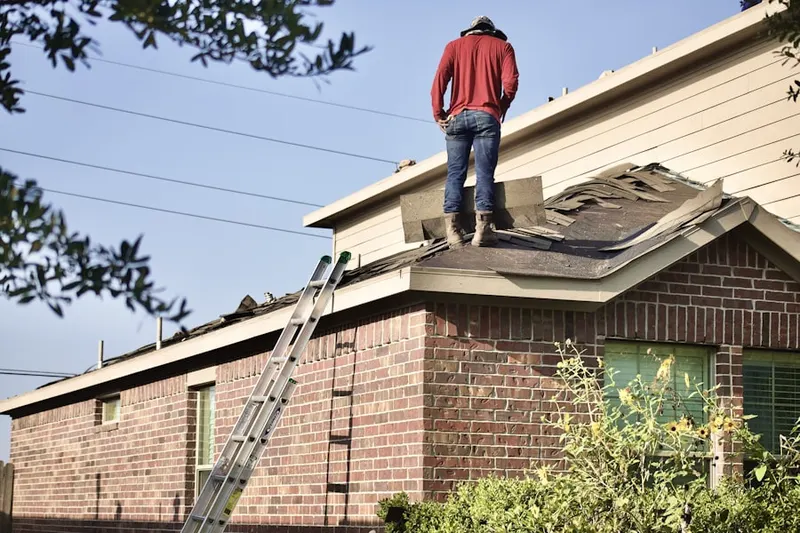 Professional roofer working on a residential roof in Mons